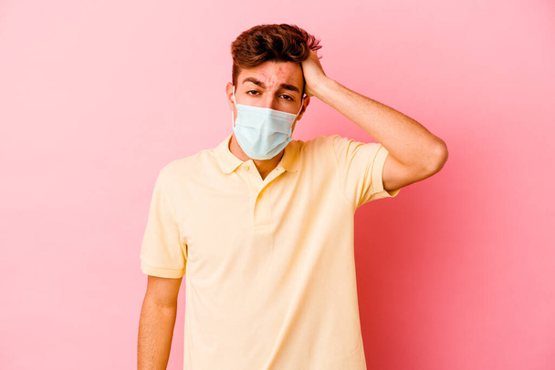 Young caucasian man wearing a protection for coronavirus isolated on pink background tired and very sleepy keeping hand on head. - Photo, Image
