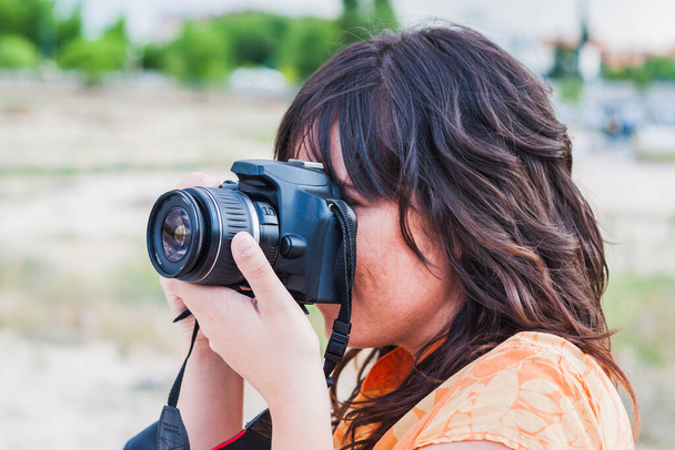 Una joven tomando fotografías con cámara réflex - Foto, Imagen
