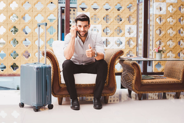 スーツケース付きのハンサムな若いビジネスマン  - 写真・画像