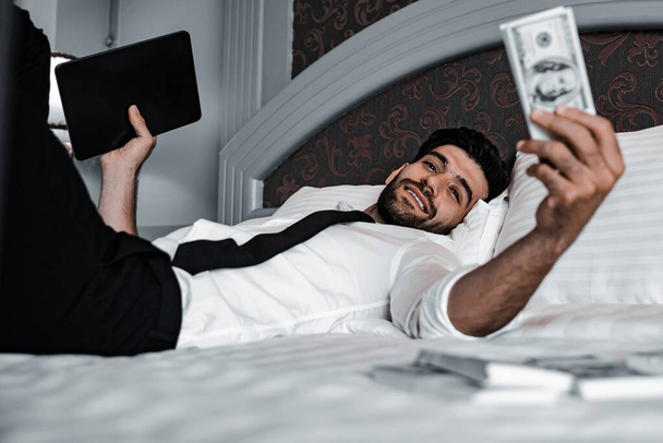 Handsome young bearded businessman with cash  - 写真・画像
