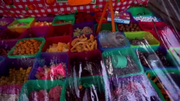 Орехи и конфеты в пластиковых контейнерах за прозрачным листом ПВХ - Кадры, видео