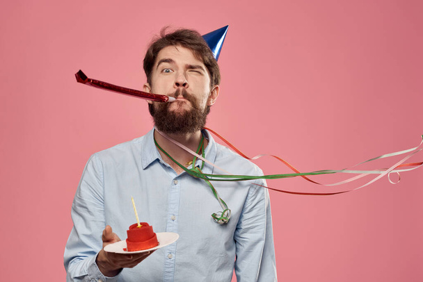 Бородатый мужчина с тортом на розовом фоне день рождения корпоративные эмоции модель одиночества - Фото, изображение