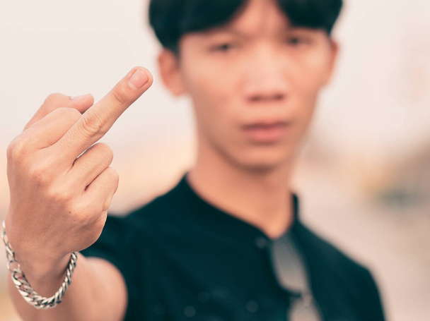 Young man raising his middle finger and angry. - Foto, imagen