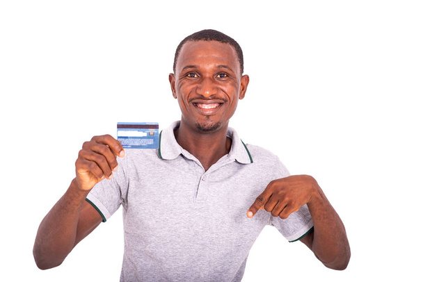 dorosły biznesmen trzymający kartę kredytową i wskazujący palcem w dół uśmiechnięty. - Zdjęcie, obraz