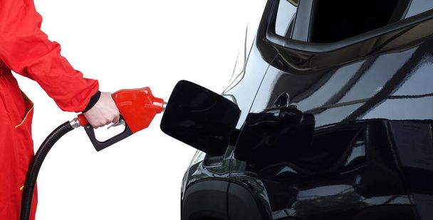 A benzinkút személyzete vörös benzinpisztolyt tart a szivattyú üzemanyagfúvókájával.                                - Fotó, kép