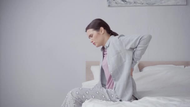 брюнетка молодая женщина прикосновение к спине во время страданий от боли - Кадры, видео