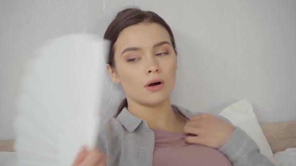 jovem morena mulher acenando ventilador de mão enquanto sofre de calor - Filmagem, Vídeo