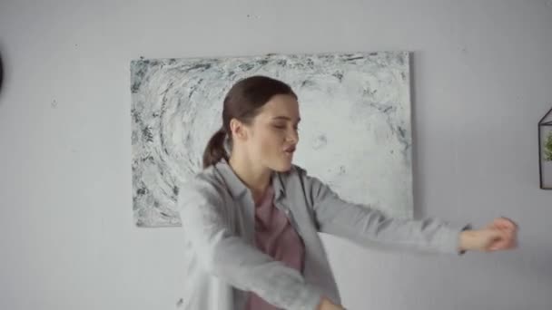 νεαρή γυναίκα χορεύει και τραγουδάει στη μοντέρνα κρεβατοκάμαρα - Πλάνα, βίντεο
