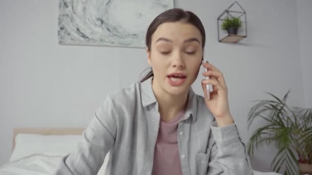 mujer joven disgustado hablando en el teléfono inteligente  - Metraje, vídeo