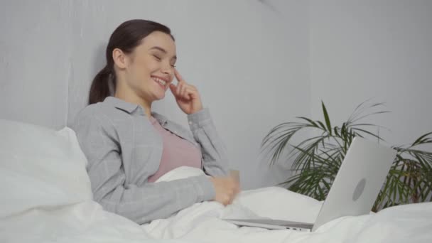 glückliche junge Frau mit Videoanruf im Schlafzimmer - Filmmaterial, Video