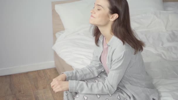 mujer preocupada en pijama esperando el resultado de la prueba de embarazo en el dormitorio - Imágenes, Vídeo