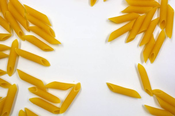 Alimento seco amarillo italiano vermicelli, pasta sólida de grano se encuentra sobre un fondo blanco.  - Foto, Imagen