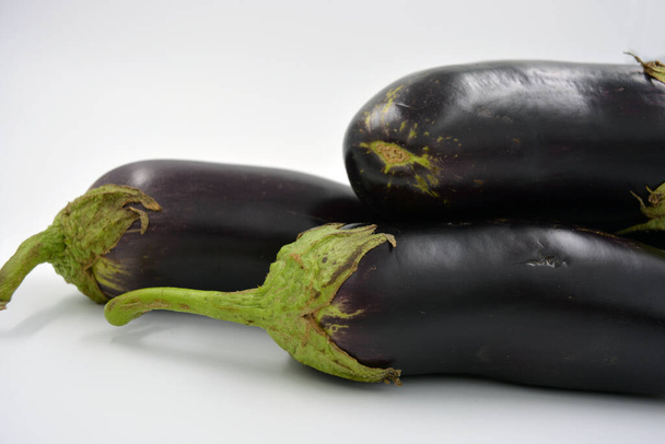 Fresh and healthy vegetables from breast, blue, purple eggplants located on a white background.  - Fotografie, Obrázek