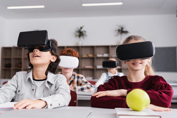 schoolchildren in vr headsets during lesson in classroom, blurred background - Photo, Image