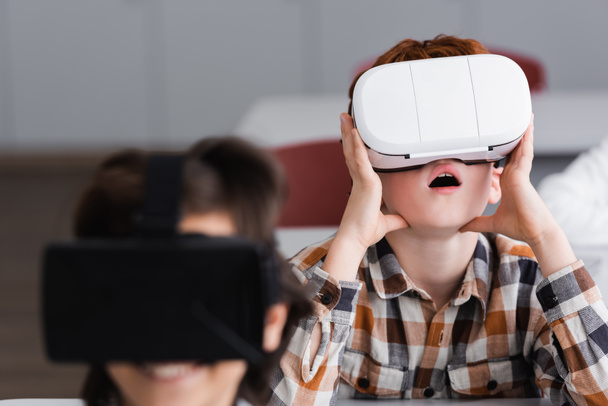 surprised boy using vr headset near classmate on blurred foreground - Photo, Image