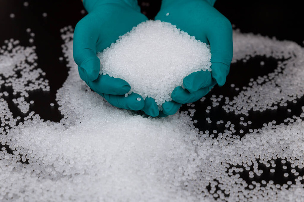 Close-up of plastic polymer granules. hand hold Polymer pellets. polymer plastic. compound polymer. Hands in rubber gloves hold plastic pellets. - Fotó, kép