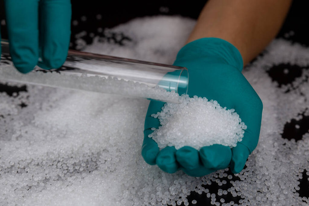Close-up of plastic polymer granules. hand hold Polymer pellets. polymer plastic. compound polymer. Hands in rubber gloves hold plastic pellets. - Foto, imagen
