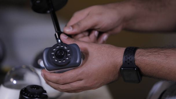 Человек чинит камеры наблюдения в сервисном центре - Фото, изображение