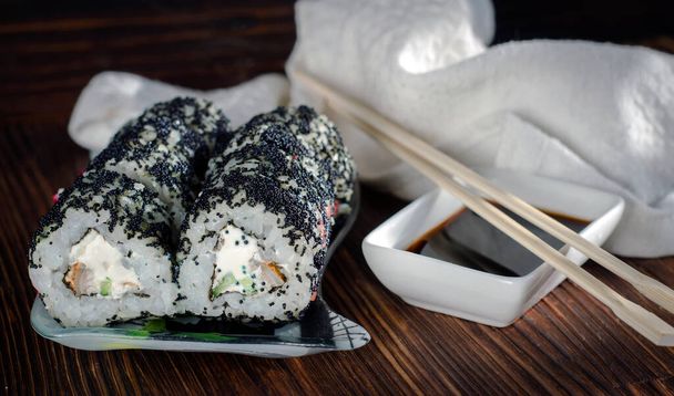 rollos de sushi en caviar masago en un plato con wasabi y jengibre - Foto, Imagen