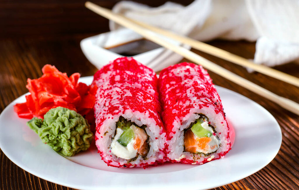rollos de sushi en caviar masago en un plato con wasabi y jengibre - Foto, imagen