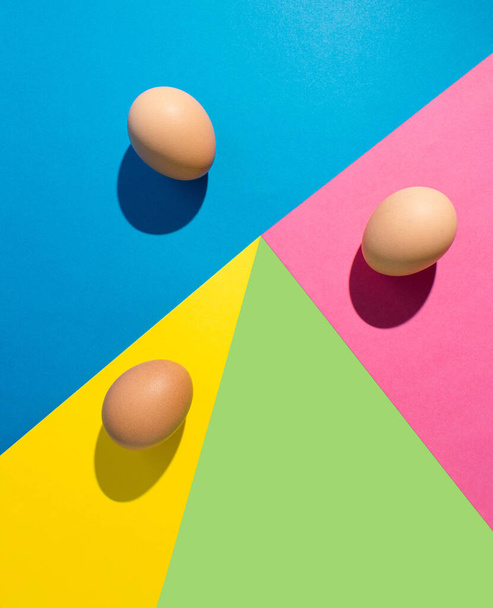 Eieren op een kleurrijke achtergrond. Blauwe, gele, groene en roze achtergrond. Concept voor Pasen. - Foto, afbeelding
