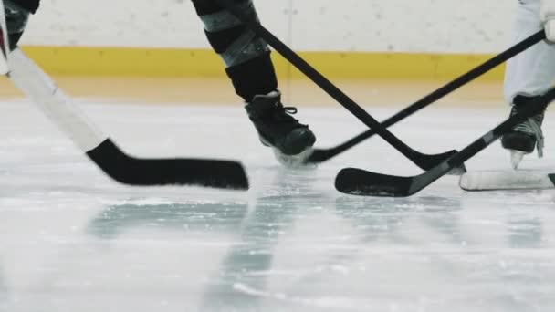 Panorámica de tiro de sección baja con lentitud de jugadores de hockey masculinos irreconocibles de pie en círculo golpeando sus palos en el hielo - Metraje, vídeo