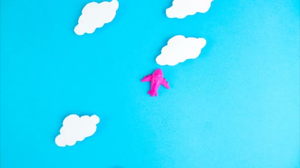 Állítsd le a mozgást. Rózsaszín kis repülő repül a háttérben a felhők kék ég. Repülőgép, utazás, légi közlekedés, zárlat vége és karantén koncepció - Felvétel, videó