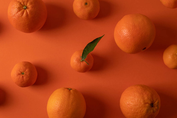 Narancsok és mandarinok narancssárga színű háttér minta - Fotó, kép
