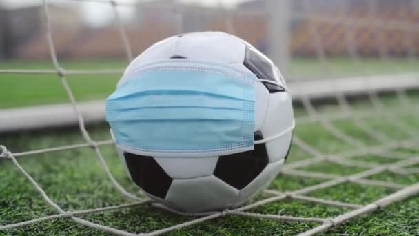 Jalkapallo Medical Mask in Goal Net. Tyhjä stadion. Jalkapallokilpailujen peruuttaminen - Materiaali, video