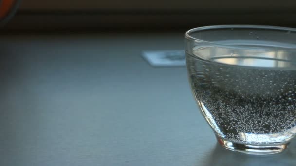 šálek s minerální vodou a pomerančem, panorama zblízka - Záběry, video