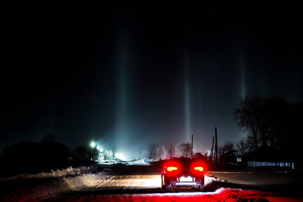 Light poles from the spotlights, imitation of the Northern Lights. Winter pillars in severe frost. - Zdjęcie, obraz