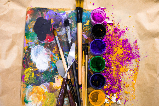 絵画ツールは、最も芸術的な方法で配置。画家のテーブルの上に水彩、ブラシ、カラーパレット付きの瓶 - 写真・画像