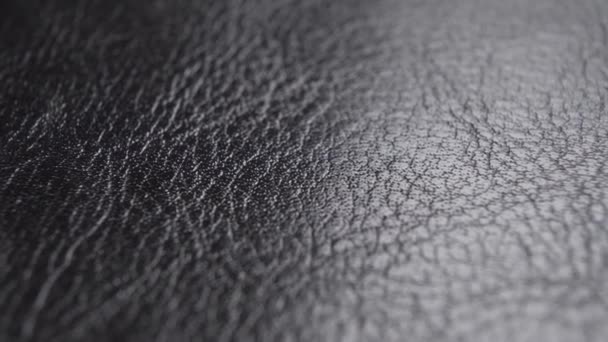 Textura abstracta arrugada de la superficie de cuero negro. Material de tapicería. Macro. Dolly Shot - Metraje, vídeo