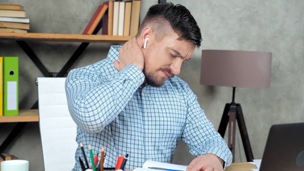 Κουρασμένος επιχειρηματίας μασάζ στο λαιμό τρίβει σφιγμένους μυς μετά από πολύ καιρό laptop εργασίας - Φωτογραφία, εικόνα