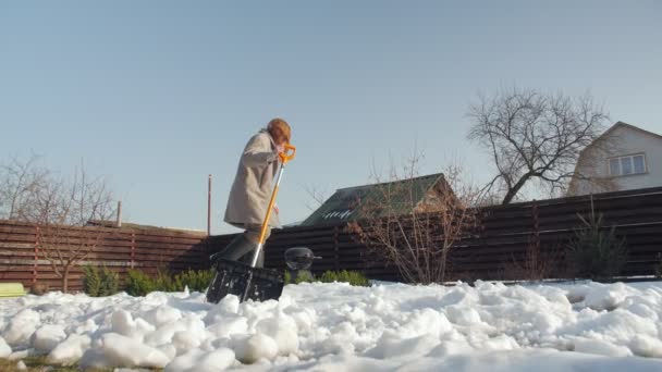 Убирает снег у дома - Кадры, видео