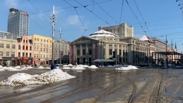 Katowice, Silesia / Polonia: 14 de febrero de 2021: personas cruzando las vías del tranvía frente al Teatro Silesiano de Katowice Polonia. - Metraje, vídeo