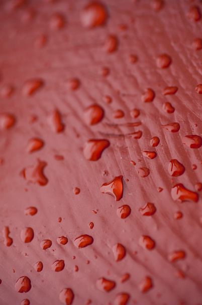 víz csepp piros felületén - Fotó, kép