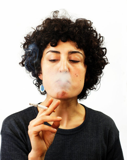Mujer joven sopla humo
 - Foto, imagen