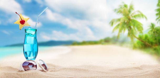 Cóctel fresco y frío en la playa tropical con palmeras y arena brillante. Vacaciones de verano mar y concepto de viaje con espacio de copia - Foto, Imagen