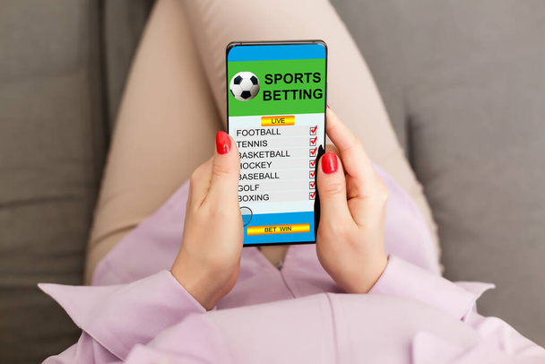 Frau hält Mobiltelefon mit Sportwetten-Webseite auf dem Bildschirm. - Foto, Bild