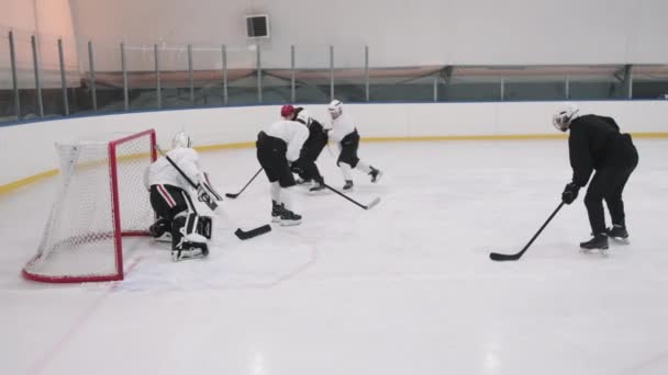 Slow-motion plný záběr hokejistů předává puk dopředu hráč v černé uniformě, vstřelil gól v brankářů brány a jásající vítězství s týmem - Záběry, video