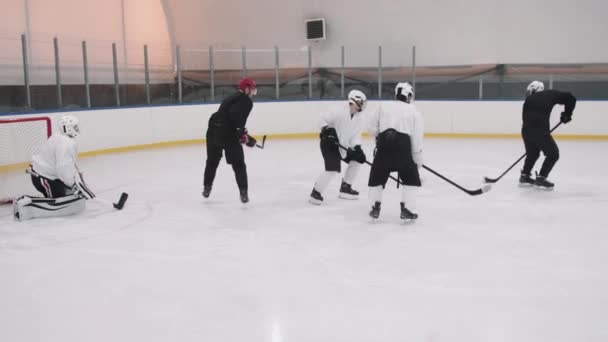 Hidasliikkeinen täysi laukaus jääkiekkoilijoiden pelin aikana, kulkee jääkiekko kiekko eteenpäin pelaaja lähellä maalivahti - Materiaali, video