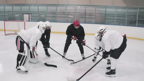Täysi korkean kulman laukaus jääkiekko valmentaja kertoo pelaajille asettua asemiin sitten alkaa pelata sisätiloissa jääareenalla - Materiaali, video