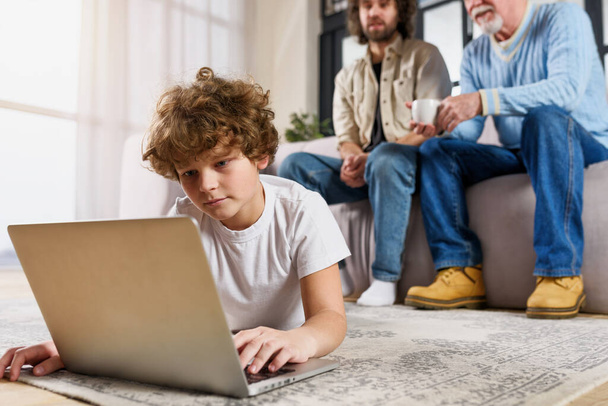 Children surfs on the web with a laptop at home with his family - Photo, image