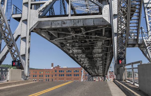 Lift Bridge Up: Het centrum deel van een grote brug toont zijn onderkant als het stijgt boven de rijbaan om passage van boten in de haven van Duluth, Minnesota. - Foto, afbeelding