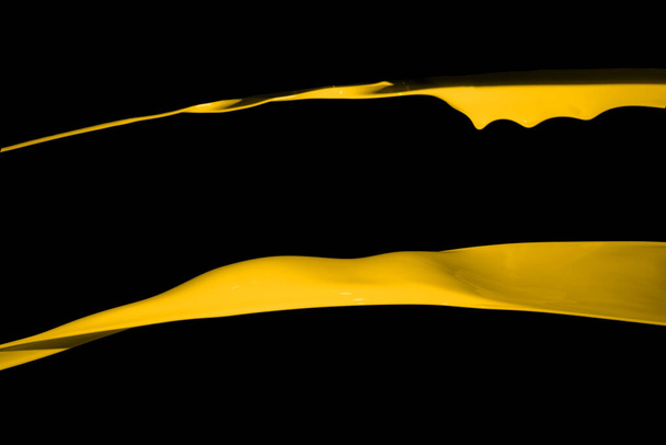 Gele verf splash geïsoleerd op zwarte achtergrond. - Foto, afbeelding