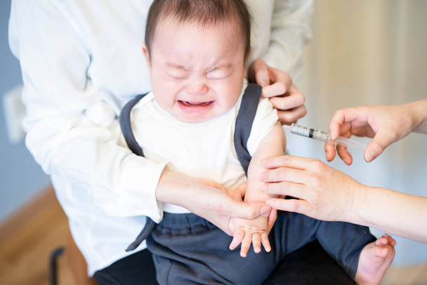 Un bébé vacciné alors qu'il est détenu par sa mère - Photo, image