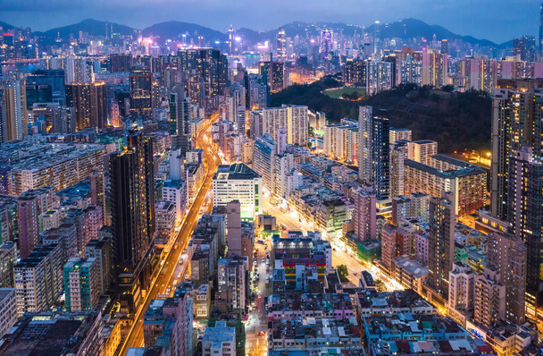 Kowloon, Hong Kong 'daki şehir merkezinin destansı hava gece görüntüsü. Cyperpunk rengi. - Fotoğraf, Görsel