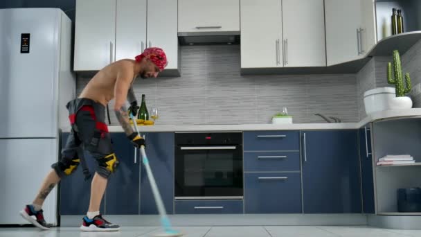 un tipo que trabaja para una empresa de limpieza, limpia el piso de la cocina y baila - Metraje, vídeo
