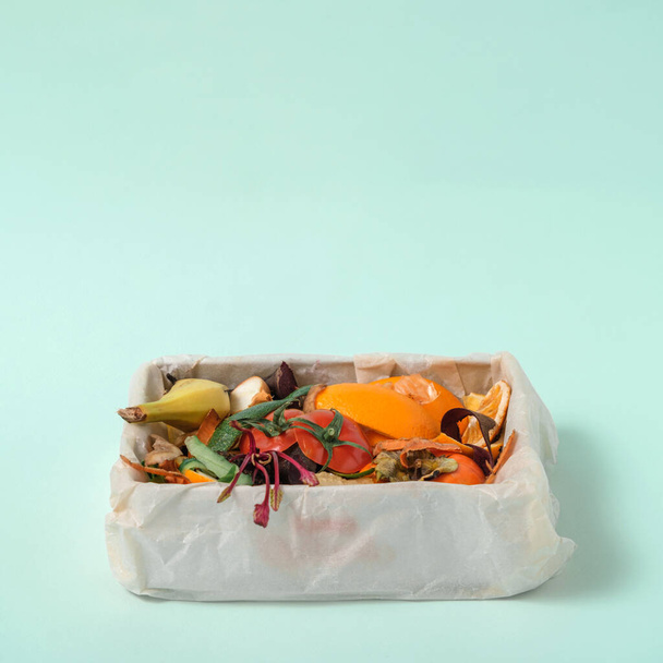 compost, restjes voedsel, groenteschillen in compostbak op blauwe achtergrond. Kopieerruimte, Duurzaam en nul afval - Foto, afbeelding
